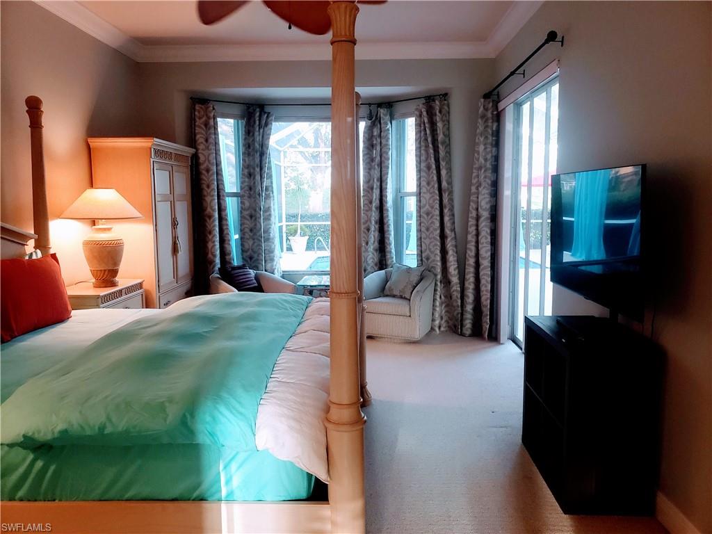 8906 Lely Island Circle Naples, FL 34113 - Photo 14 of 36 a spacious bedroom with a bed and a large window