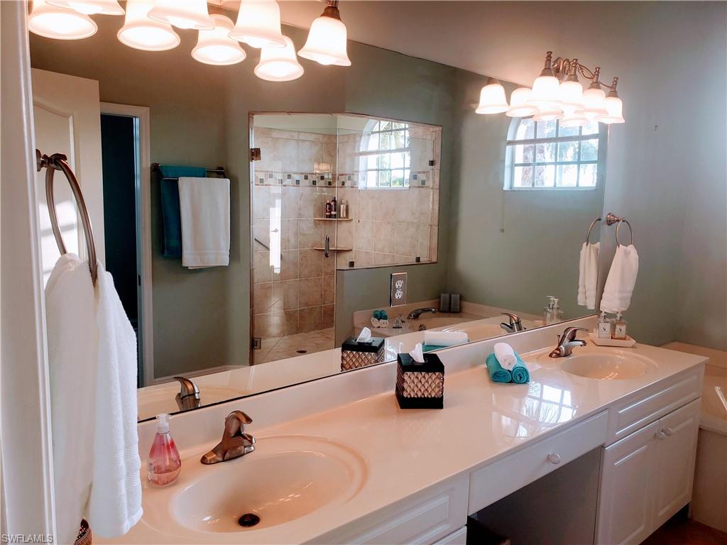 8906 Lely Island Circle Naples, FL 34113 - Photo 16 of 36 a bathroom with a sink double vanity and a mirror