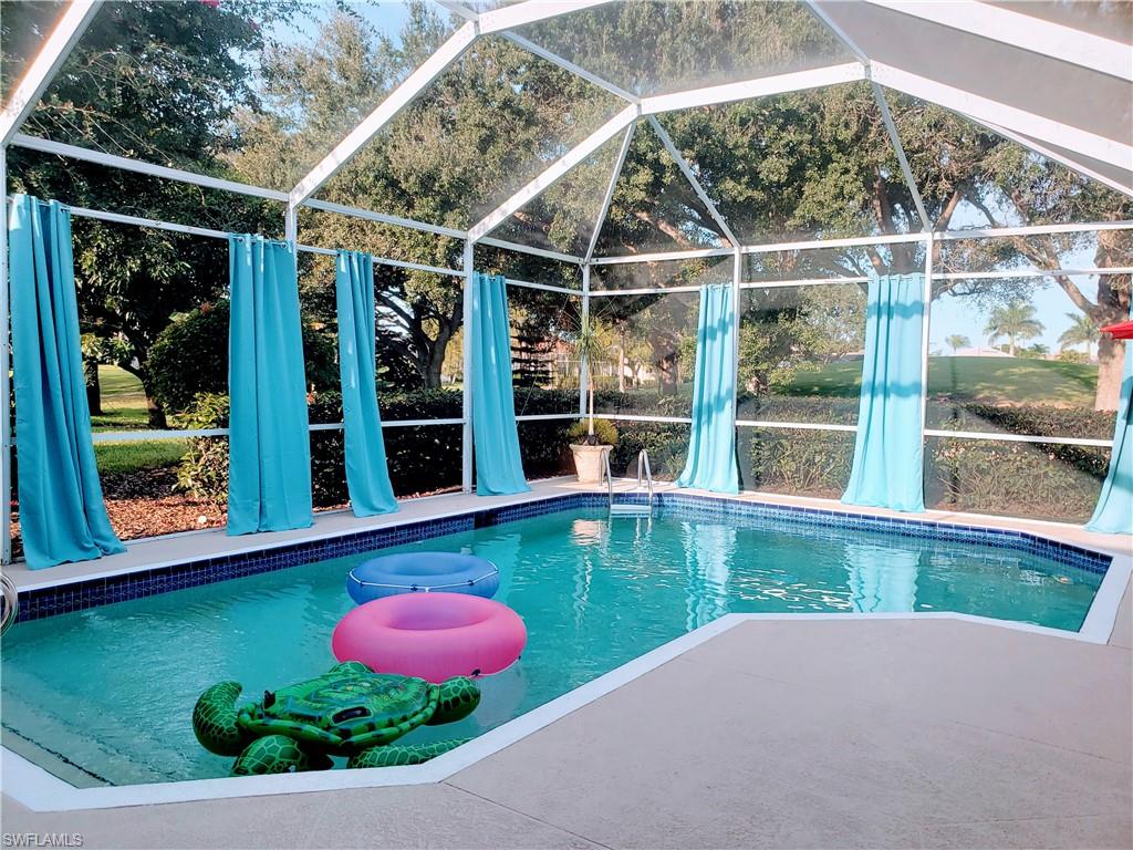 8906 Lely Island Circle Naples, FL 34113 - Photo 20 of 36 a view of a backyard with table and chairs and potted plants