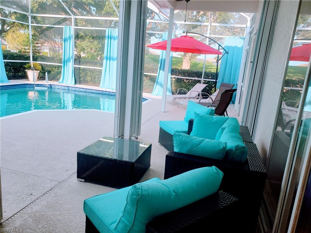 8906 Lely Island Circle Naples, FL 34113 - Photo 23 of 36 a living room with furniture and a large window