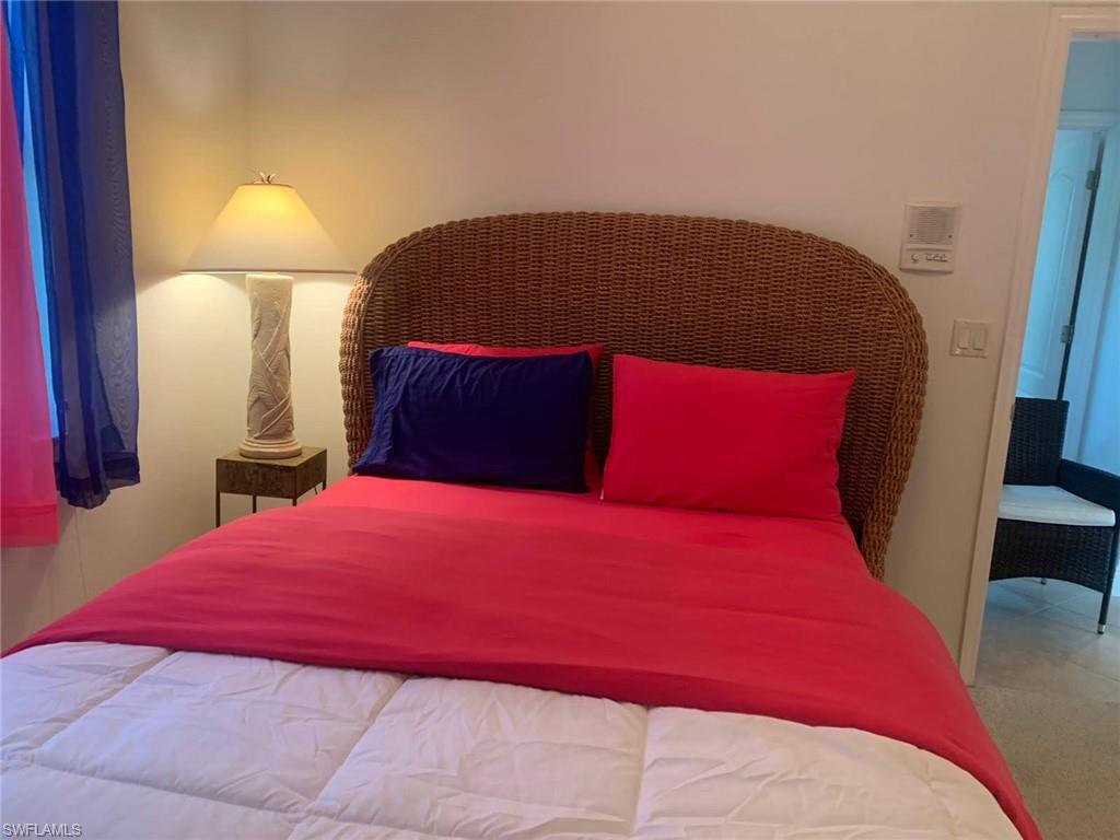 8906 Lely Island Circle Naples, FL 34113 - Photo 27 of 36 a bedroom with a bed and a lamp