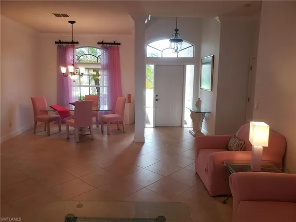 a living room with furniture a chandelier and a dining room