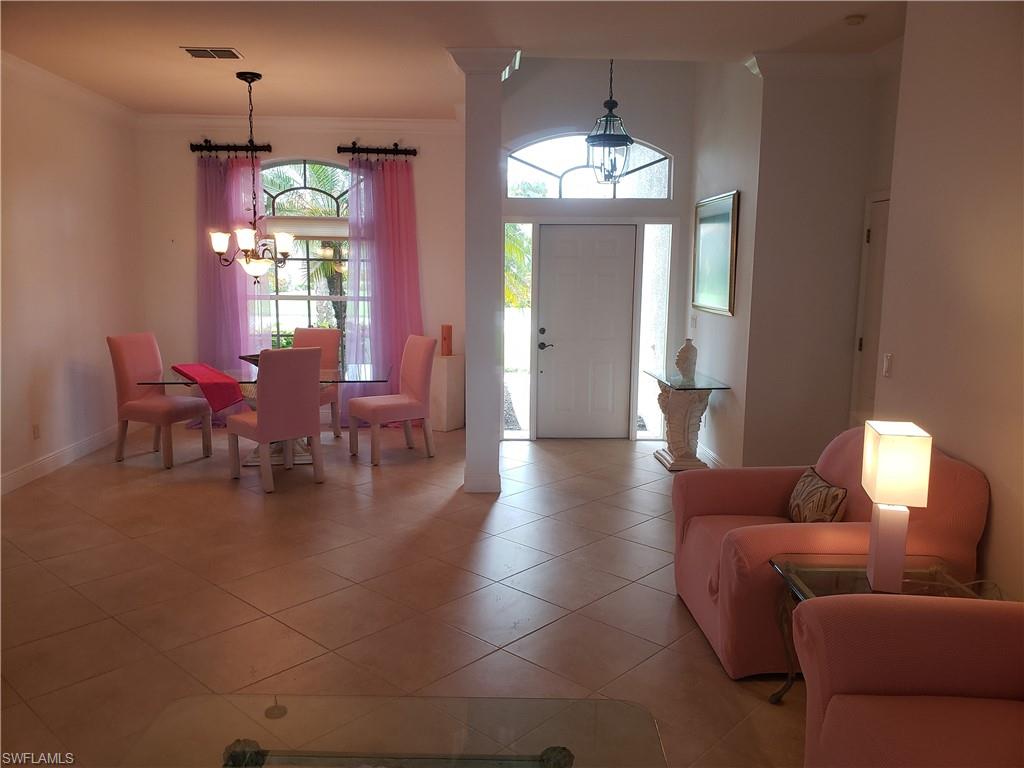 8906 Lely Island Circle Naples, FL 34113 - Photo 6 of 36 a living room with furniture a chandelier and a dining room