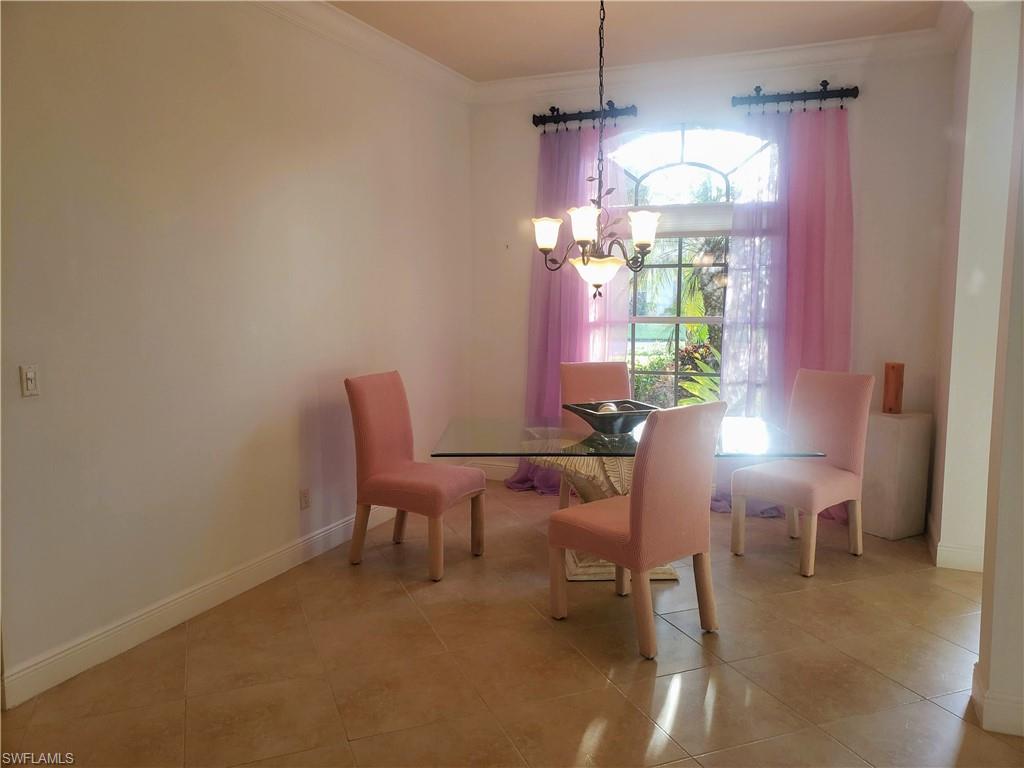 8906 Lely Island Circle Naples, FL 34113 - Photo 8 of 36 a dining room with furniture and a chandelier
