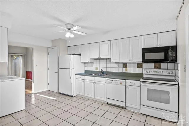 a kitchen with white cabinets appliances and sink