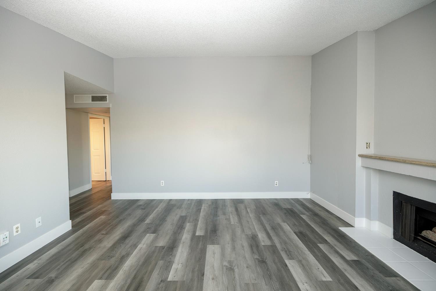 1313 Floyd Avenue, Unit 122 Modesto, CA 95355 - Photo 12 of 35 a view of empty room with wooden floor and fireplace