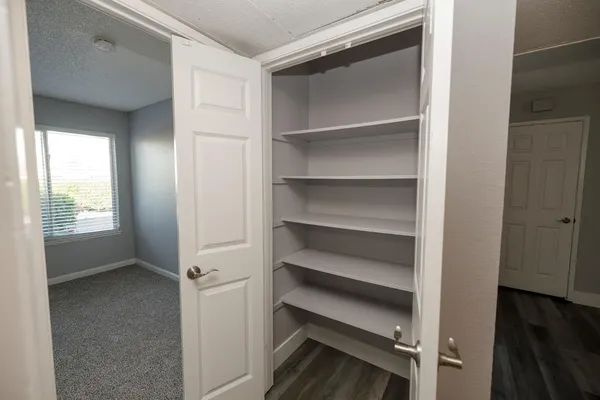a view of walk in closet with empty racks