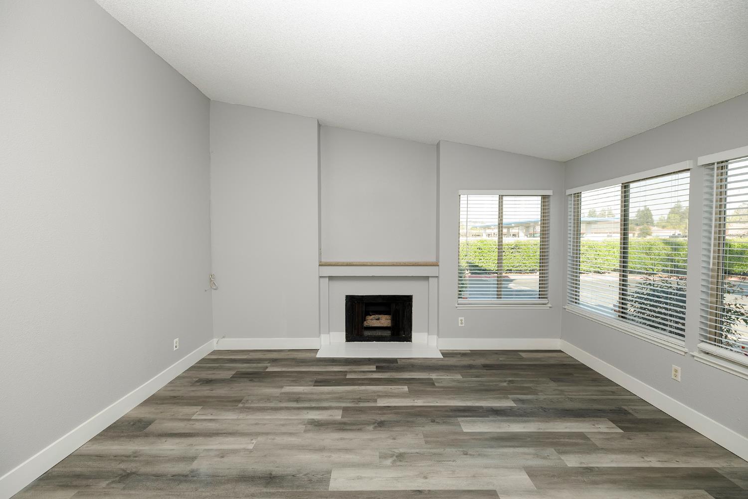 1313 Floyd Avenue, Unit 122 Modesto, CA 95355 - Photo 6 of 35 a view of an empty room with wooden floor and a window