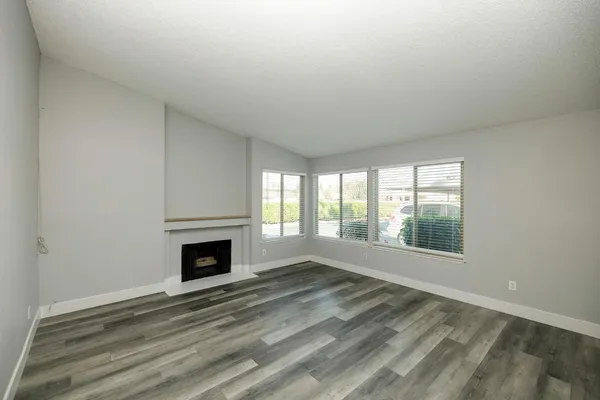 wooden floor fireplace and windows in an empty room