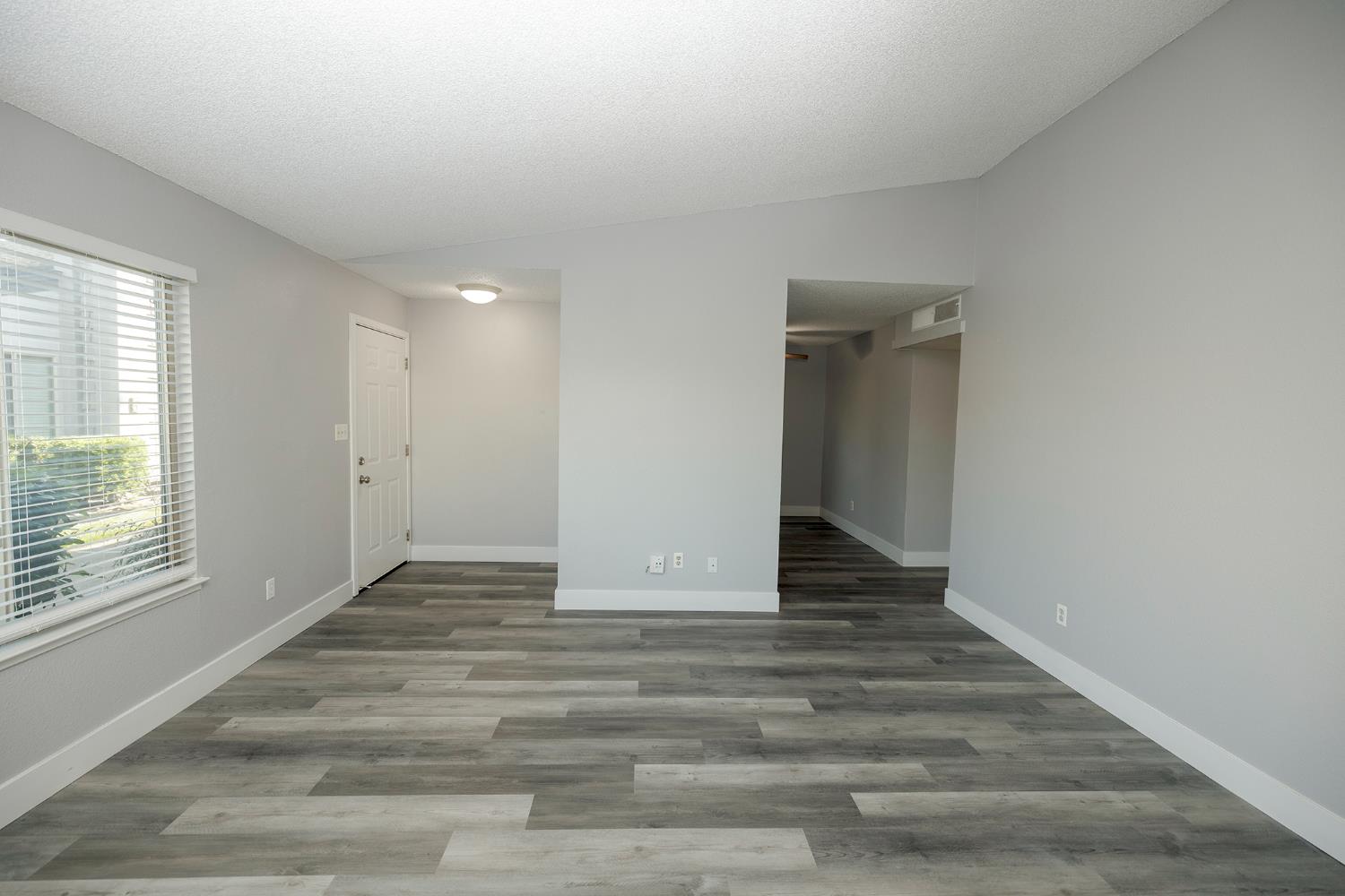 1313 Floyd Avenue, Unit 122 Modesto, CA 95355 - Photo 10 of 35 a view of an empty room with wooden floor and a window
