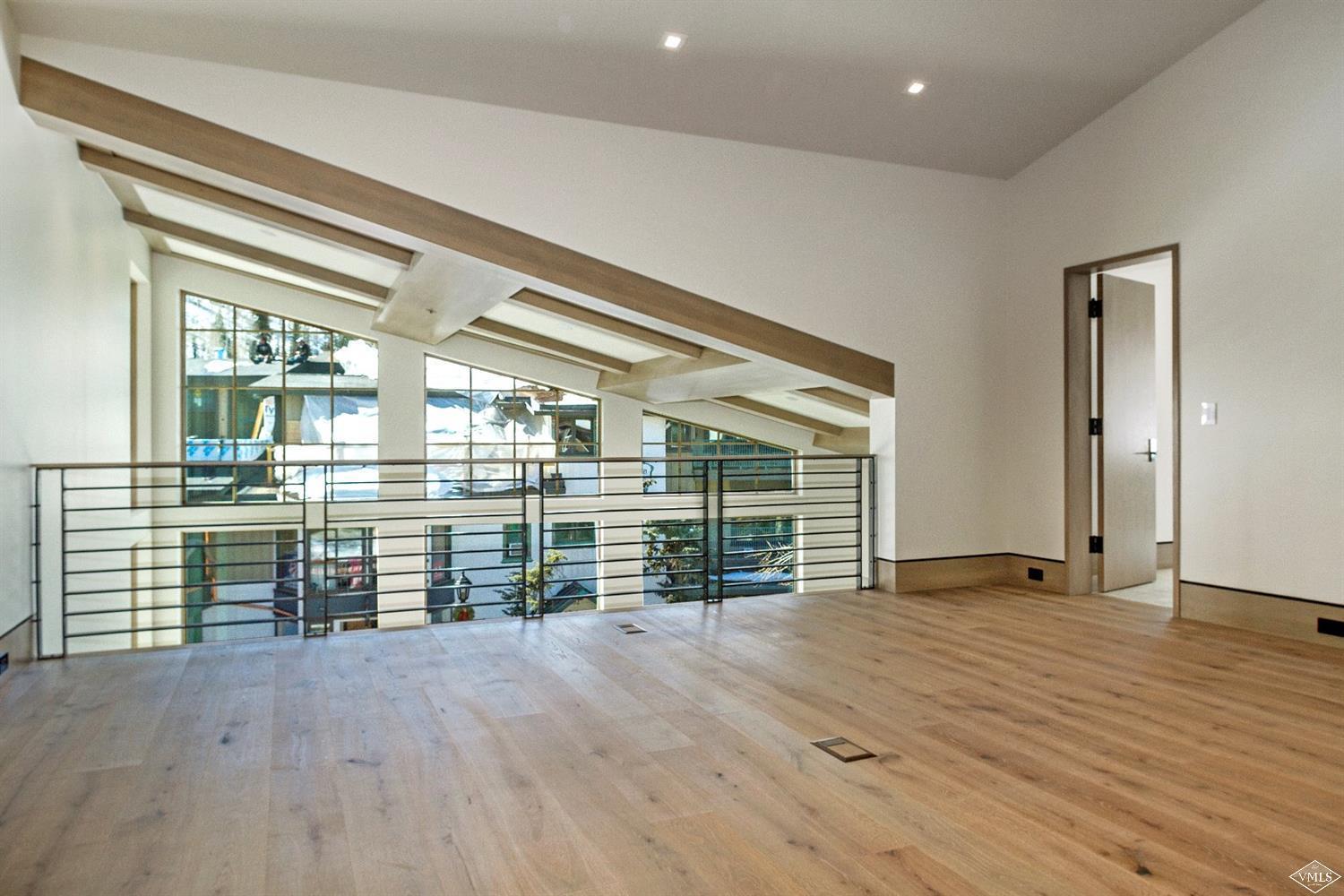 304 Bridge Street, Unit R3 Vail, CO 81657 - Photo 13 of 25 an empty room with wooden floor and windows