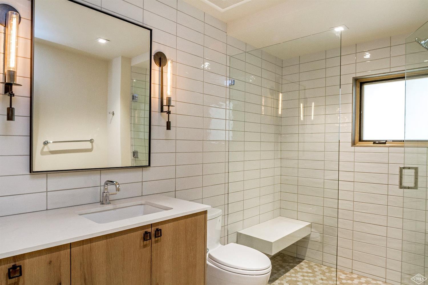 304 Bridge Street, Unit R3 Vail, CO 81657 - Photo 21 of 25 a bathroom with a granite countertop toilet sink and mirror