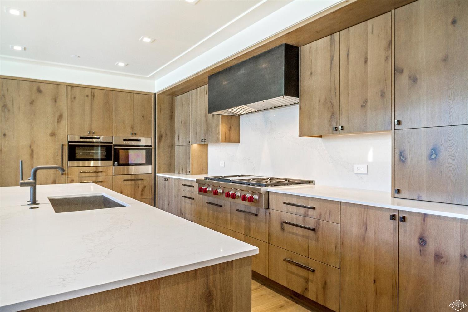 304 Bridge Street, Unit R3 Vail, CO 81657 - Photo 7 of 25 a kitchen with wooden cabinets and stainless steel appliances