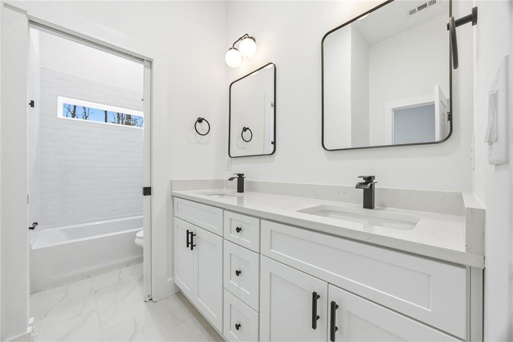 730 Primrose Lane Pendergrass, GA 30567 - Photo 28 of 40 a bathroom with a double vanity sink mirror and bathtub