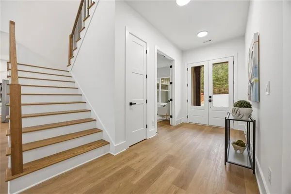 a view of a livingroom with wooden floor and stairs