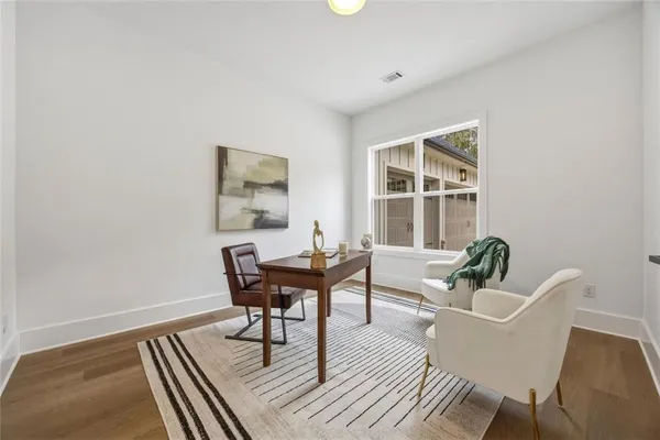 a work room with furniture wooden floor and windows
