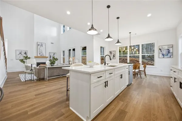 a large white kitchen with kitchen island a large island in the center