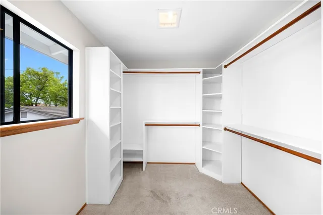 a view of walk in closet with empty racks