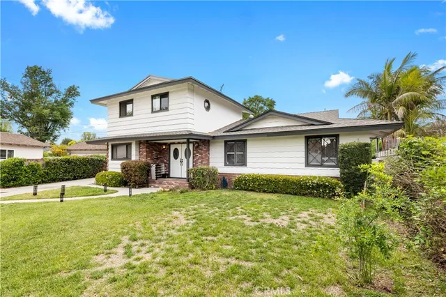 a view of a house with a yard and potted plants