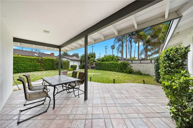 a view of patio with table and chairs and potted plants