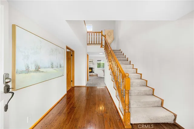 a view of a hallway with wooden floor and staircase