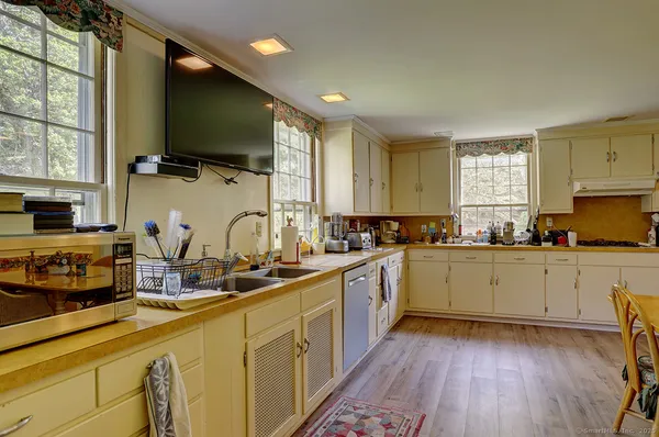 a kitchen with sink a microwave and cabinets