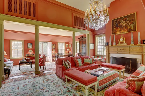 a living room with furniture a fireplace and large windows