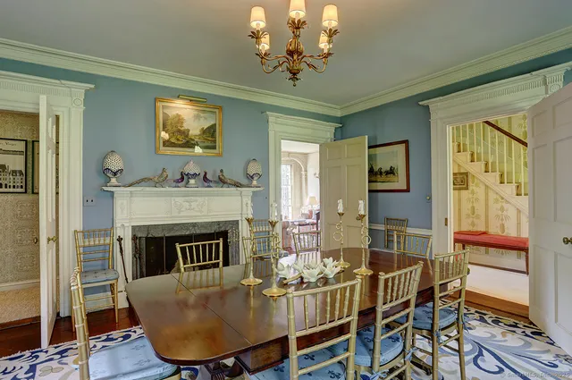 a dining room with furniture a fireplace and wooden floor