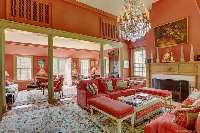 a living room with furniture a fireplace and large windows