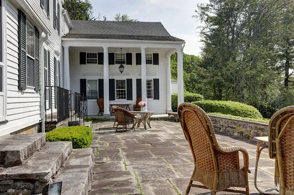 a view of a patio with table and chairs and wooden fence
