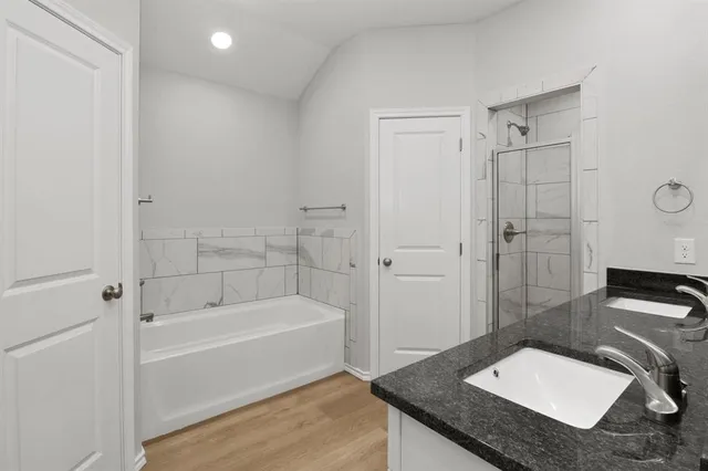 a bathroom with a granite countertop sink a toilet and shower