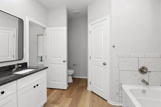 a spacious bathroom with a granite countertop tub sink and mirror