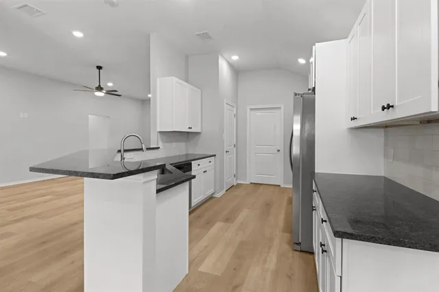 a kitchen with stainless steel appliances granite countertop a sink stove and refrigerator