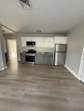 a kitchen with a refrigerator and a stove top oven