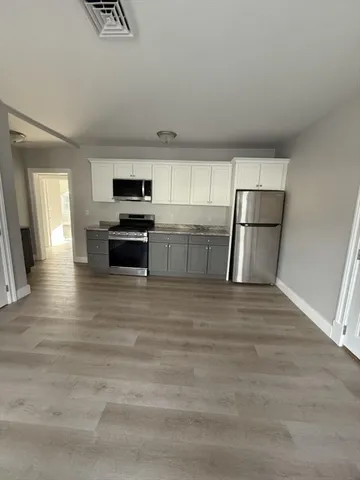 a kitchen with a refrigerator and a stove top oven