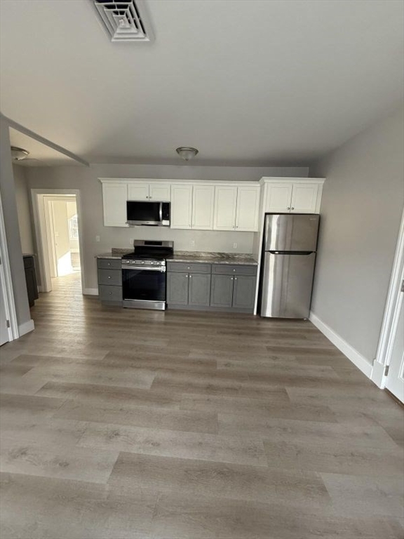 72 Belmont Street, Unit 3 FRONT Fall River, MA 02720 - Photo 2 of 8 a kitchen with a refrigerator and a stove top oven