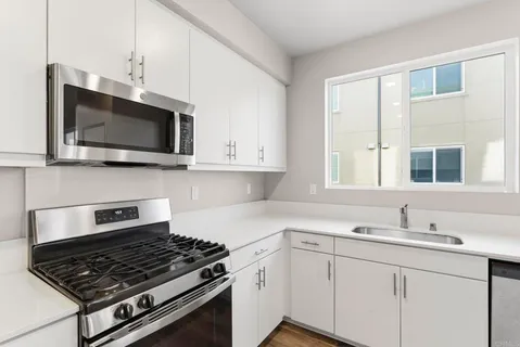 a kitchen with stainless steel appliances a stove a microwave sink and cabinets