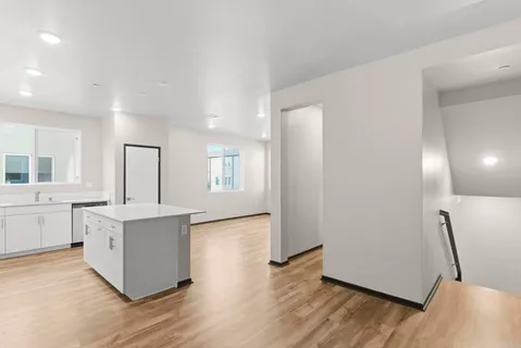 a view of kitchen with wooden floor and electronic appliances