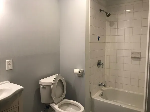 a white toilet sitting next to a bath tub