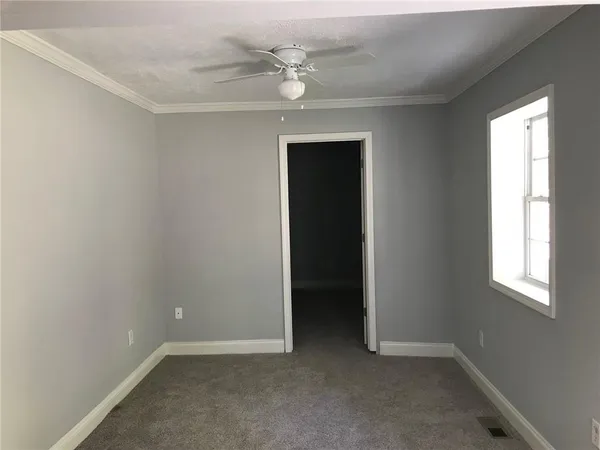 an empty room with a window and a ceiling fan