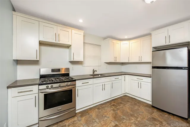 a kitchen with granite countertop cabinets stainless steel appliances and a sink