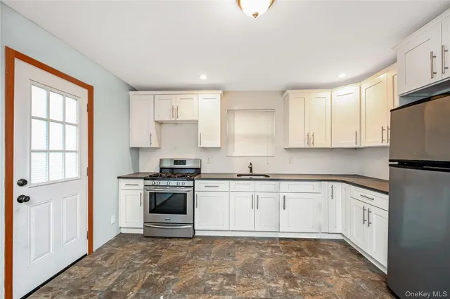 a kitchen with stainless steel appliances granite countertop a stove a sink and a refrigerator