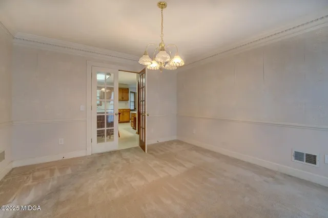 a view of a livingroom with a chandelier fan and windows