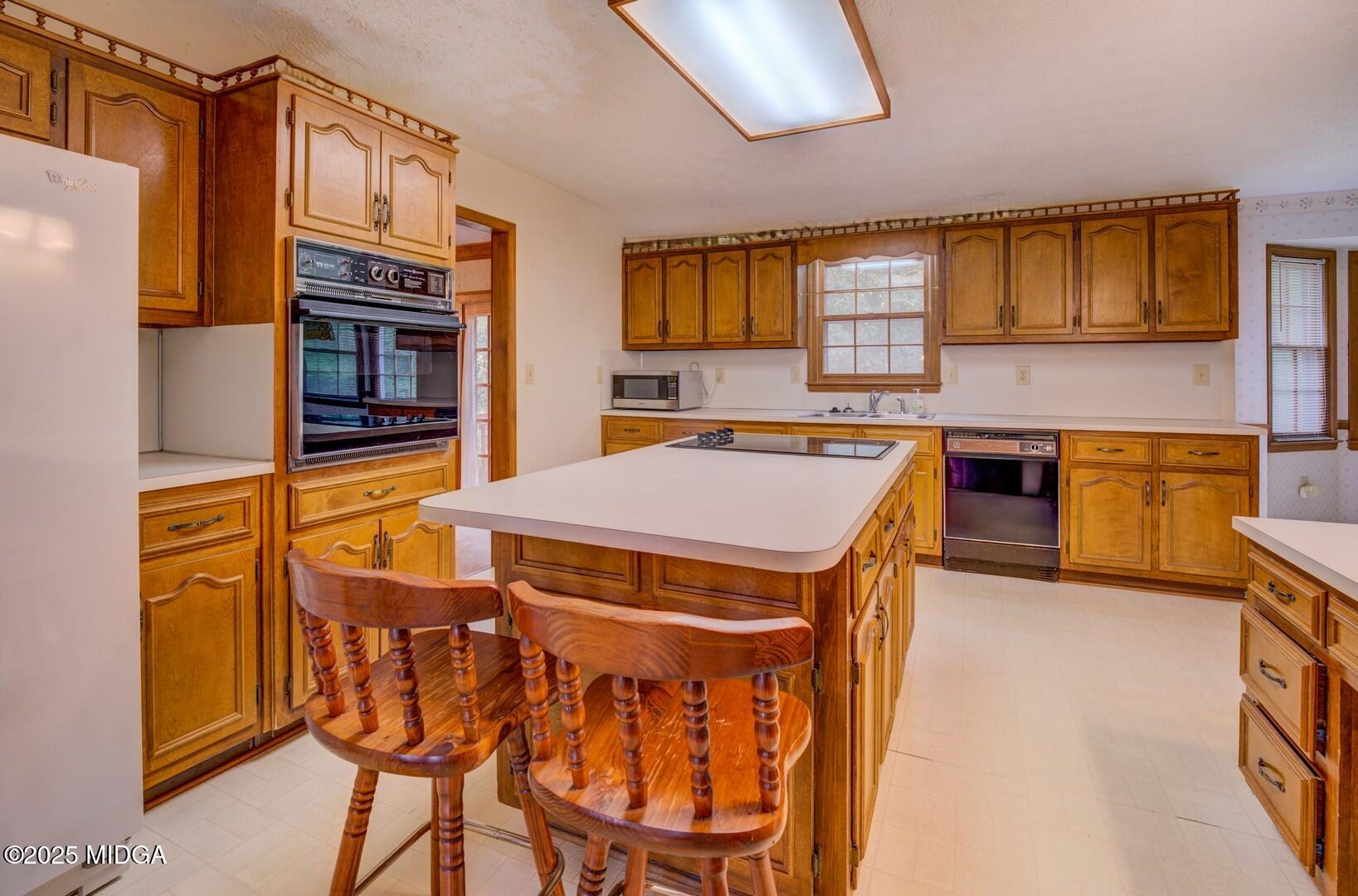 5633 Fox Den Trail Lithonia, GA 30038 - Photo 13 of 44 a kitchen with stainless steel appliances granite countertop a stove a sink dishwasher and a refrigerator with wooden floor