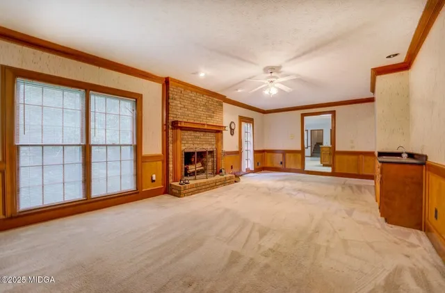a view of a livingroom with a fireplace and a ceiling fan