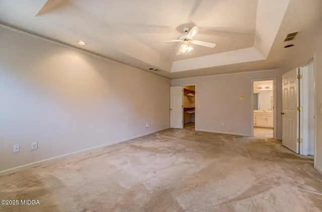 an empty room with an entryway and fan