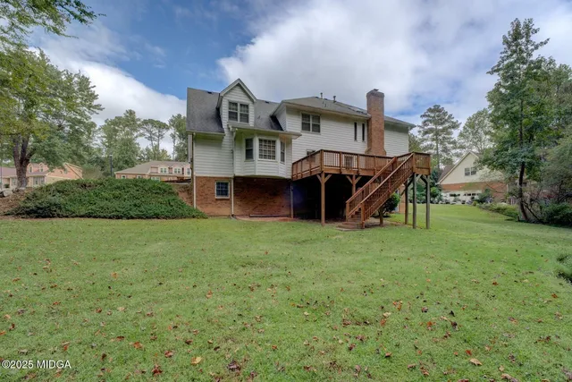 a view of a big house with a big yard and large trees