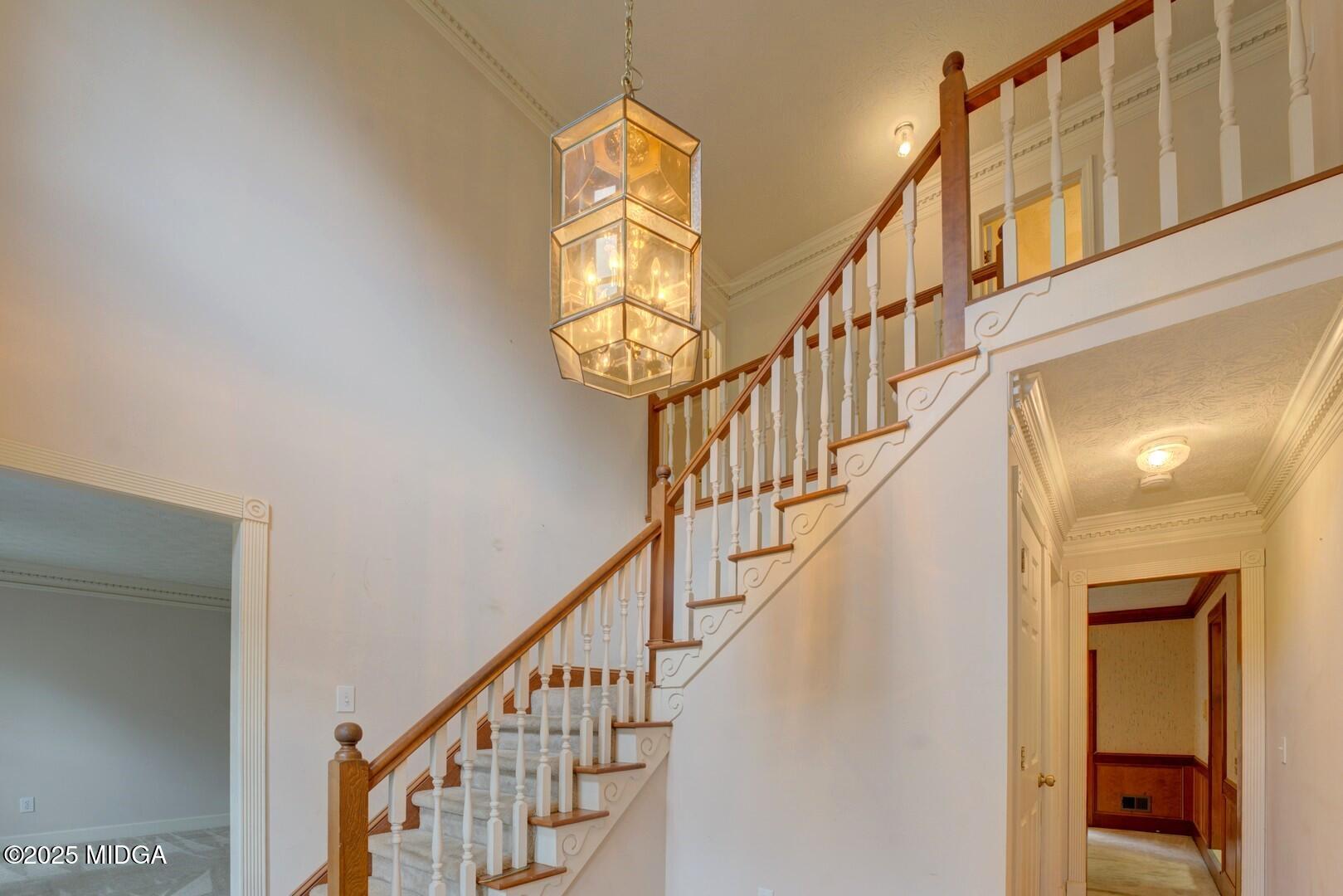5633 Fox Den Trail Lithonia, GA 30038 - Photo 7 of 44 a view of staircase with railing and a chandelier