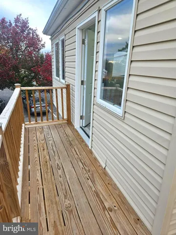 a balcony with wooden floor and white walls