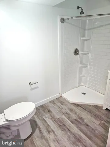 a white toilet sitting next to a bath tub and a shower